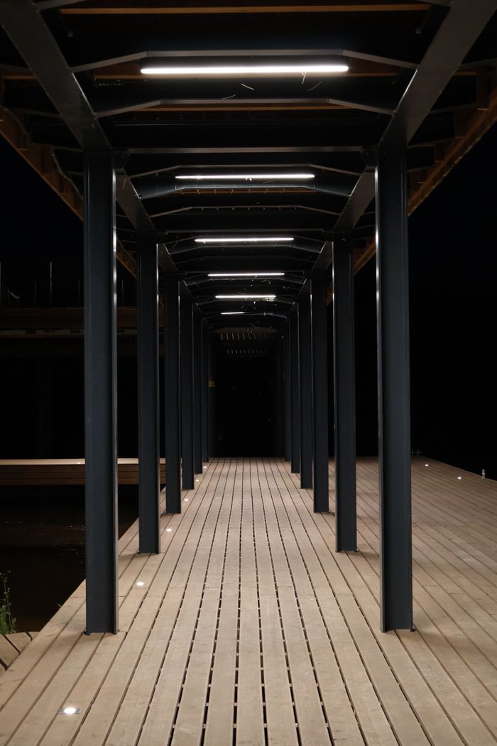 Symmetrical view of an illuminated wooden deck at night in Starachowice, Poland.